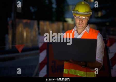 Hombre maduro, trabajador de la construcción en el sitio de construcción en el c