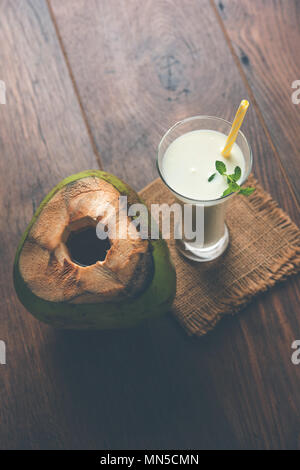 Sabor a coco lassi blanco liso o aderezado con una sacudida de leche de coco y hojas de menta. Enfoque selectivo Foto de stock