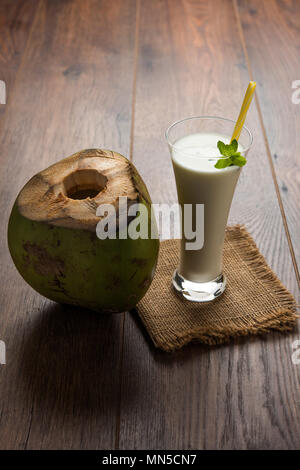 Sabor a coco lassi blanco liso o aderezado con una sacudida de leche de coco y hojas de menta. Enfoque selectivo Foto de stock