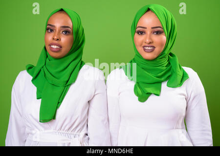 Africano joven mujer musulmana contra croma con fondo verde Foto de stock