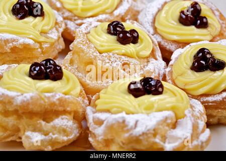 Las rosquillas di San Giuseppe (choux pasteles rellenos con crema y amarena, Italia) Foto de stock