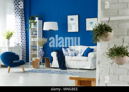 Las plantas sobre pared de ladrillo en el salón azul y blanco Foto de stock