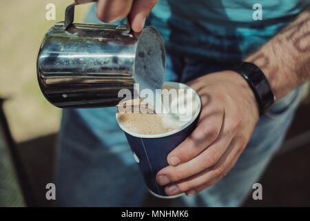 un barista prepara un capuchino, con vapor desde el Café exprés