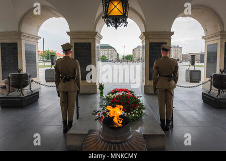 Vista trasera de guardias estacionados en el interior de la Tumba del Soldado Desconocido en Varsovia con la llama eterna, la plaza Pilsudski visible cerca de Varsovia, Polonia Foto de stock