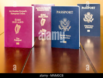 El irlandés (Unión Europea) y los Estados Unidos de América los pasaportes se encuentran una junto a la otra, y se refleja en una tabla de madera. Foto de stock