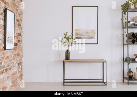 Simple pintura sobre madera mesa consola con ramitas en un jarrón de cristal en la moderna sala interior Foto de stock