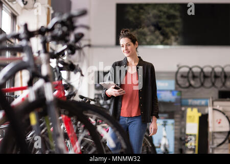Retrato de un propietario de una pequeña empresa en una tienda de bicicletas