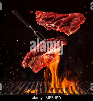 Carnes a la parrilla con fuego. Trozos de carne cruda se fríen sobre un  fuego real Fotografía de stock - Alamy