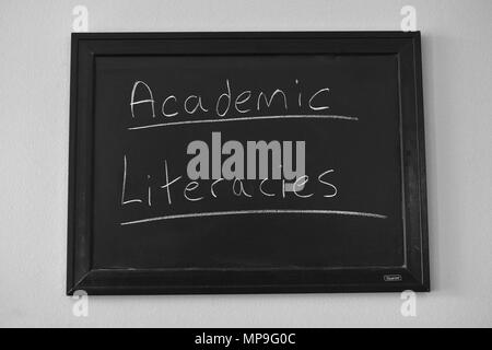 Alfabetizaciones académicas escritas en blanco tiza en una pizarra en la pared. Foto de stock