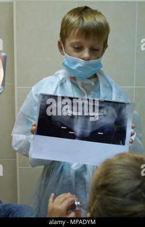 Niño juega en un dentista. Elegir una profesión Foto de stock
