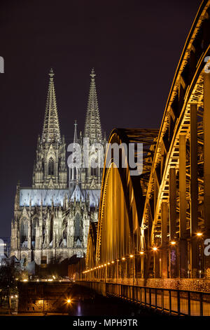 Colonia puente Hohenzollern en frente de la catedral de noche Foto de stock