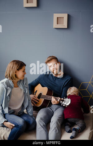 Familia feliz jugando música con su hijo en casa