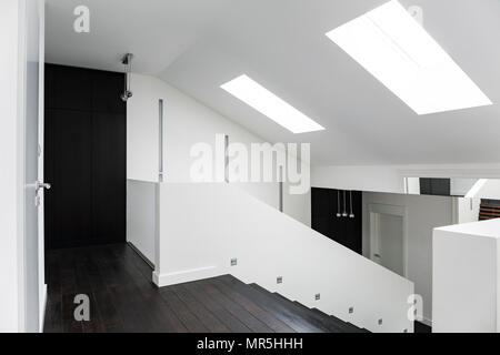 Moderna villa blanca corredor con escaleras de madera oscura.