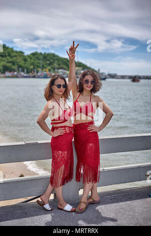 Dos mujeres vestidas igual en vestidos rojos. Tailandia Sudeste asiático Foto de stock