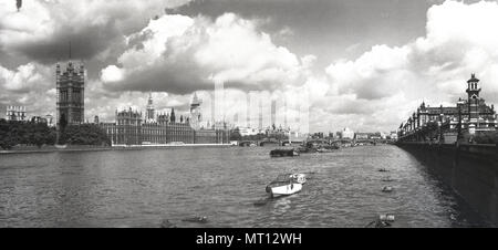 1950, histórica, una amplia vista hacia abajo y a través del río Támesis, Londres, mostrando a la izquierda, el Palacio de Westminster, lugar de encuentro del Gobierno del Reino Unido. En el palacio están las dos Cámaras del Parlamento, la Cámara de los comunes y la Cámara de los Lores.