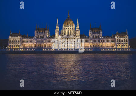 Escena nocturna del edificio del parlamento húngaro en el banco del río Danubio, visto desde el lado de Buda.