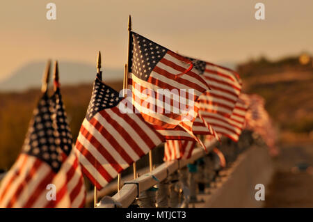 Las banderas americanas conectado a un puente sobre el Río Santa Cruz soplar el viento en Green Valley, Arizona, EE.UU. Foto de stock