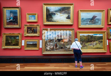 Mujer mirando las pinturas de la galería Victoria McManus en el interior de la galería de arte y museo en Dundee, Escocia, Reino Unido, Tayside Foto de stock