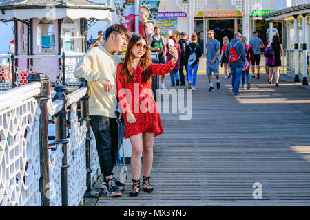 Asia oriental de una pareja posando para un selfie en Brighton Pier Foto de stock