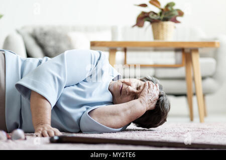 Mujer senior con un dolor de cabeza después de caer en casa Foto de stock