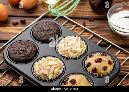En bakeware diferentes Muffins o magdalenas pan sobre fondo de madera  broun. Muffin receta básica. Muffins caseros para el desayuno o el postre.  Ingredientes Fotografía de stock - Alamy
