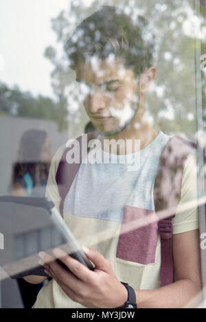 Estudiante universitario mirando tableta digital entre clases Foto de stock