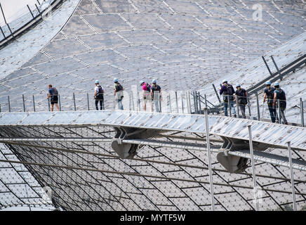 08 de junio de 2018, en Alemania, en Munich: Los Visitantes al Parque Olímpico de pie sobre el techo del estadio futurista, que fue construido para los Juegos Olímpicos de 1972. Foto: Peter Kneffel/dpa Foto de stock