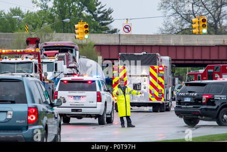 El 18 de mayo de 2018 Stevensville MI EE.UU.; un oficial de policía en ropa de lluvia dirige el tráfico en la escena de un accidente grave Foto de stock