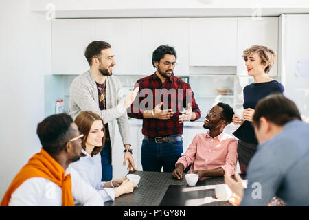 La gente de negocios a divertirse en la cocina con el interior moderno