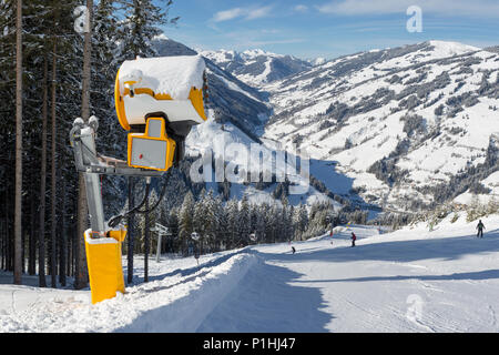 Un gran cañón de nieve al lado de una estación de esquí en un día soleado en Zell Am See, Austria. Foto de stock