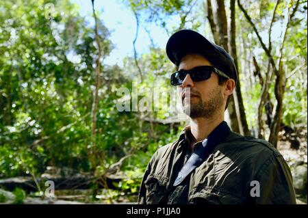 Joven con gafas de sol y un sombrero en un bosque, Parque Nacional Paluma, Rollingstone QLD, Australia Foto de stock