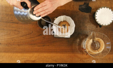 Barista verter agua sobre el café tierra con filtro Foto de stock