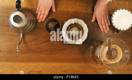 Canaleta de vertido de agua caliente de café en polvo en el filtro. Foto de stock
