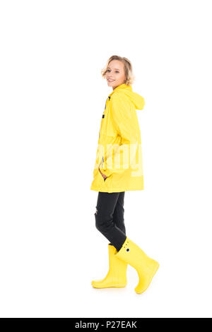 Mujer joven con chubasquero amarillo y botas de goma en la