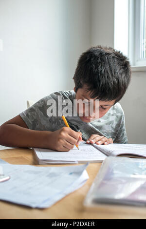 Surrey, UK-alumno de primaria trabajando en ejercicios de matemáticas