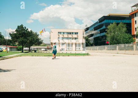 Joven adolescente jugando con la cometa en un día soleado en el patio de la escuela Foto de stock