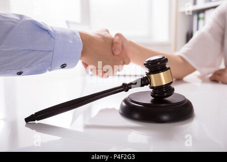 Close-up de maceta delante del Juez un apretón de manos con su cliente