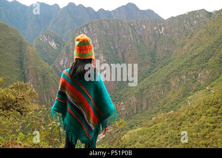 Una mujer joven mirando la vista espectacular de la cordillera de la montaña Huayna Picchu, Cusco, provincia de Urubamba de Perú Foto de stock