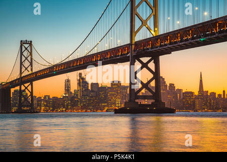 Classic vistas panorámicas del horizonte de San Francisco con el famoso Puente de la Bahía Oakland iluminado en la hermosa luz del atardecer dorado al atardecer en verano Foto de stock