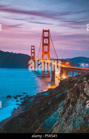 Classic vista panorámica del famoso Golden Gate Bridge visto desde la pintoresca playa de Baker en el crepúsculo del atardecer hermoso post con el cielo azul y las nubes al atardecer en