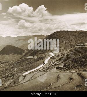 Vista aérea de campos de terrazas y calzada con un vehículo militar en una región montañosa de la provincia de Kiangsu o provincia de Yunnan en China 1946 Foto de stock