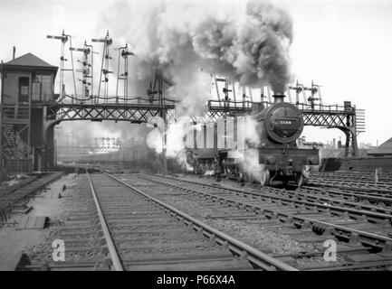 Un antiguo ferrocarril Midland 4-4-0, compuesto de tres cilindros de clase  4P piloteando un tren de doble cabeza pasado un impresionante conjunto de  semáforos señales. C1955 Fotografía de stock - Alamy