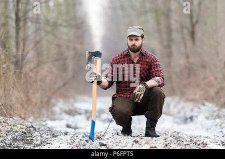 Trabajador de leñadores de pie en los bosques con AX Foto de stock