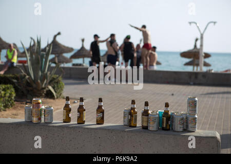 Botellas y latas de cerveza vacías, turistas alemanes en el fondo de El Arenal, en la calle Mallorca, España Foto de stock