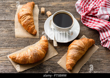 Taza de café y croissants sobre mesa de madera. Concepto de desayuno. Vista superior Foto de stock