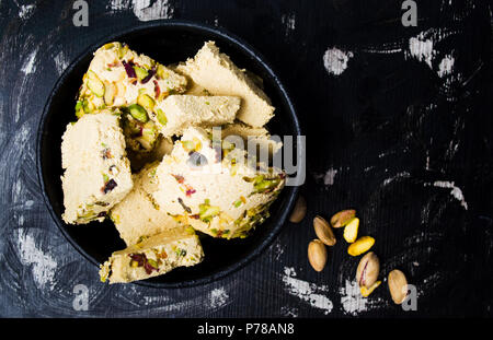 Postre Halva con pistachos en una placa oscura Foto de stock