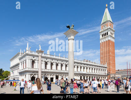 Multitud de turistas en frente de la Biblioteca Marciana en Piazetta San Marco, Venecia, Véneto, Itlay con el campanario (Campanile) y dos columnas.
