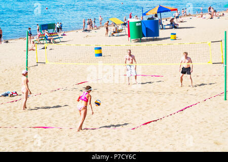 Un grupo de personas, hombres y mujeres jugando voleibol de playa Foto de stock