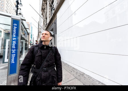 La Ciudad de Nueva York, Estados Unidos, 7 de abril de 2018: Manhattan Midtown de Nueva York Herald Square, 6th Avenue road, persona feliz hombre de personas peatones caminando, mirando hacia arriba