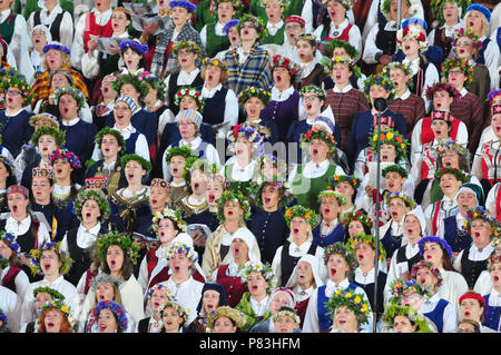 Riga, Letonia. 8 de julio, 2018. Los miembros del coro en trajes nacionales, realizar durante el concierto de clausura de Letonia la XXVI Nationwide canción y danza XVI celebración en Riga, Letonia, el 8 de julio de 2018. Este concierto celebrado la semana nacional de la canción y el baile de celebración, en la que aproximadamente 43.000 bailarines y cantantes de Letonia y del extranjero participaron. Crédito: Janis/Xinhua/Alamy Live News Foto de stock